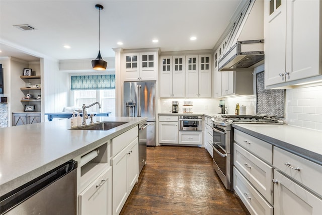 kitchen with pendant lighting, sink, stainless steel appliances, and white cabinets