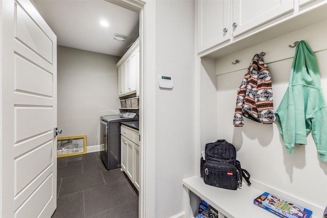 interior space with cabinets, dark tile patterned floors, and washing machine and clothes dryer