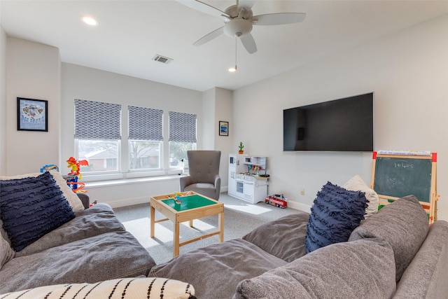 carpeted living room with ceiling fan