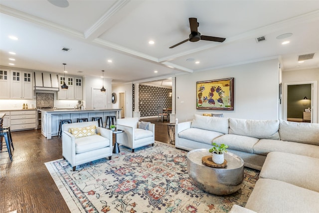 living room with dark hardwood / wood-style flooring, ceiling fan, crown molding, and beamed ceiling