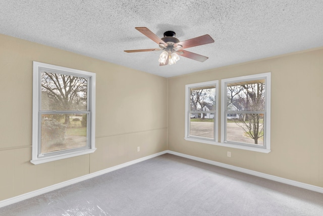 carpeted spare room with ceiling fan and a textured ceiling