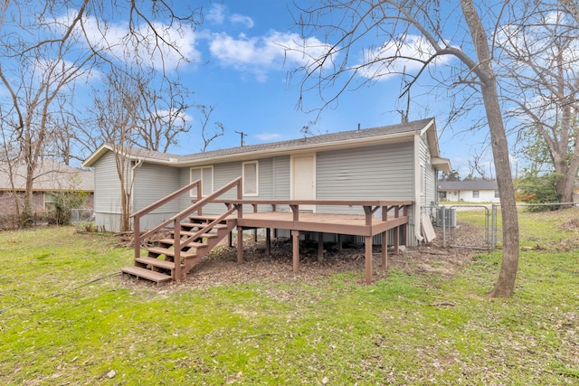 back of house featuring a wooden deck and a yard