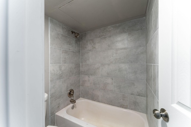 bathroom featuring tiled shower / bath and toilet