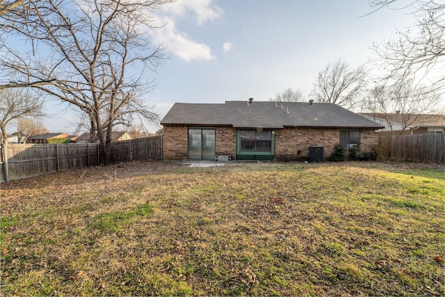 rear view of property with a yard and cooling unit