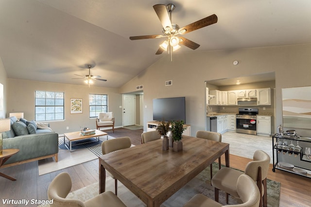 dining room featuring ceiling fan, vaulted ceiling, and light hardwood / wood-style flooring