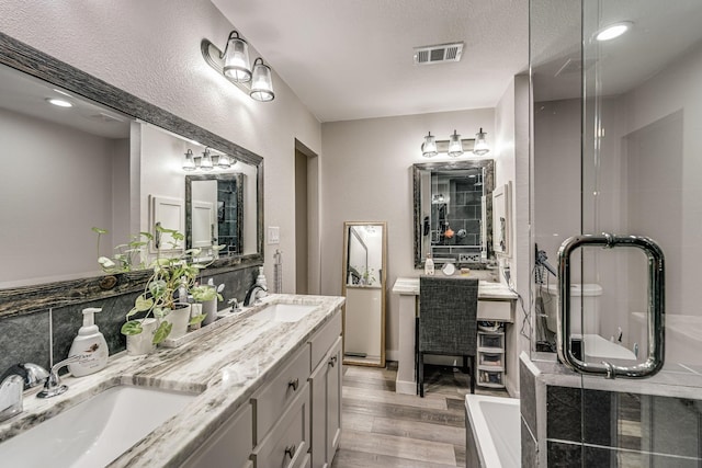 bathroom featuring vanity, separate shower and tub, hardwood / wood-style floors, and a textured ceiling