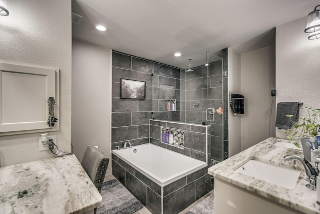 bathroom with vanity, independent shower and bath, and a textured ceiling