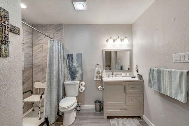 bathroom with walk in shower, hardwood / wood-style floors, vanity, and toilet