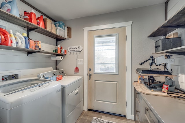 laundry area with cabinets, washer and clothes dryer, and light wood-type flooring