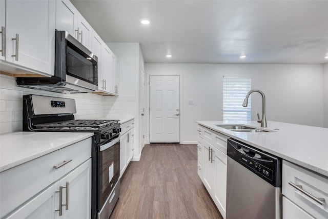 kitchen featuring white cabinetry, appliances with stainless steel finishes, light hardwood / wood-style floors, and sink