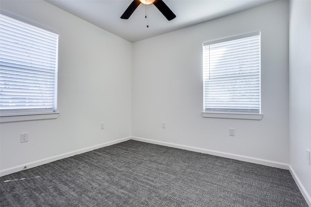 spare room with dark carpet and ceiling fan