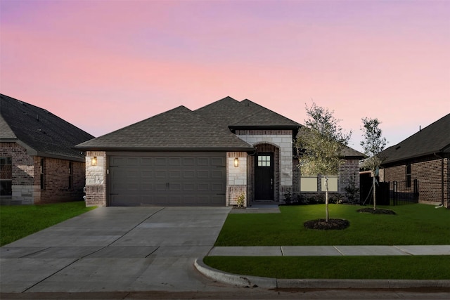 view of front of home with a garage and a lawn