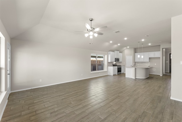 unfurnished living room with dark hardwood / wood-style flooring, lofted ceiling, and ceiling fan