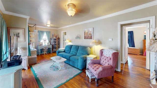 living room with ceiling fan, ornamental molding, and wood-type flooring