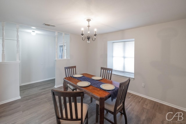 dining space with an inviting chandelier and dark hardwood / wood-style flooring