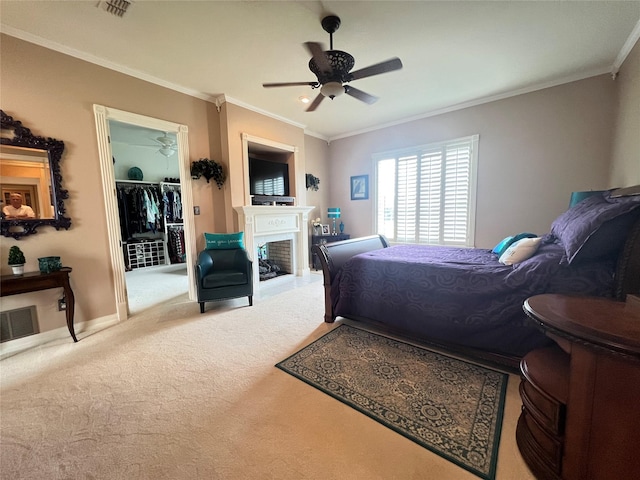 bedroom with crown molding, ceiling fan, carpet flooring, a spacious closet, and a closet