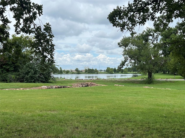 view of home's community featuring a water view and a lawn