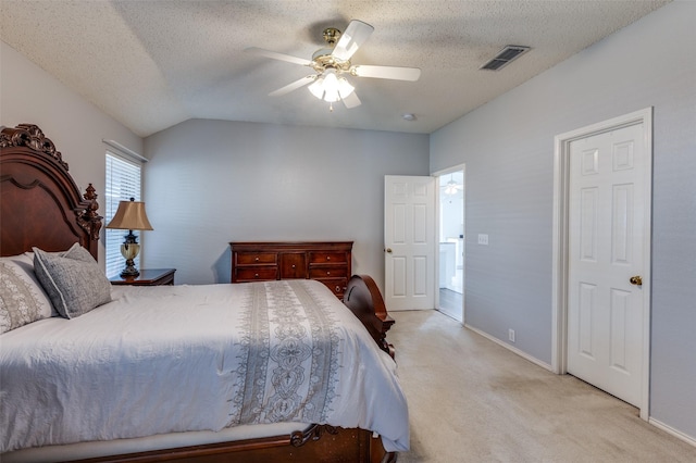 carpeted bedroom with ceiling fan, vaulted ceiling, and a textured ceiling