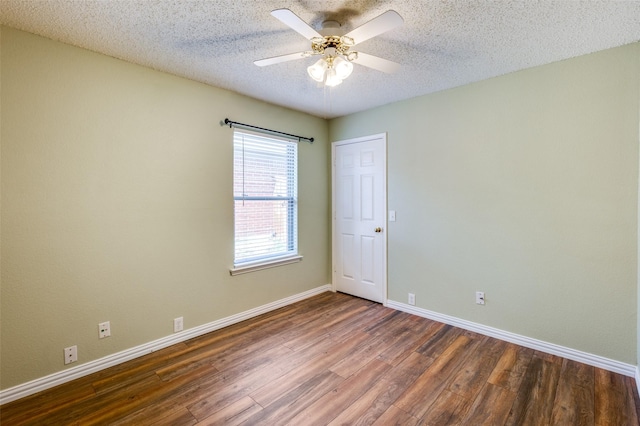 spare room featuring ceiling fan, dark wood-type flooring, and a textured ceiling