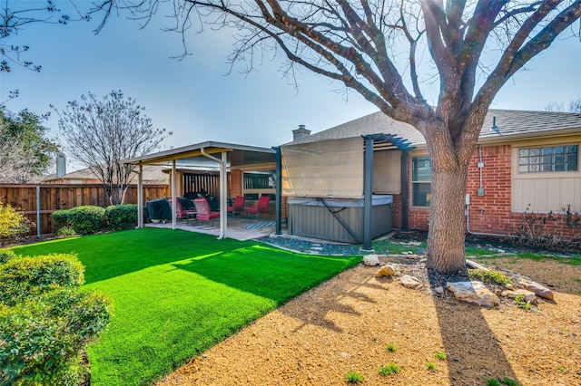 back of property featuring a yard, a hot tub, a pergola, and a patio area