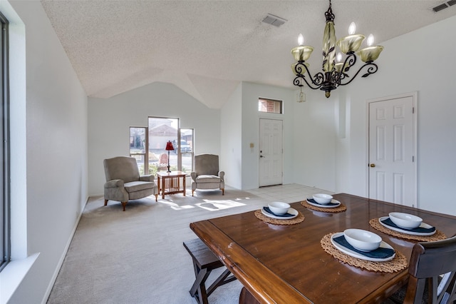 carpeted dining room with lofted ceiling, a textured ceiling, and an inviting chandelier