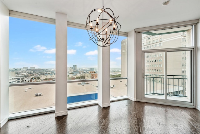 doorway with expansive windows, dark hardwood / wood-style floors, and a chandelier