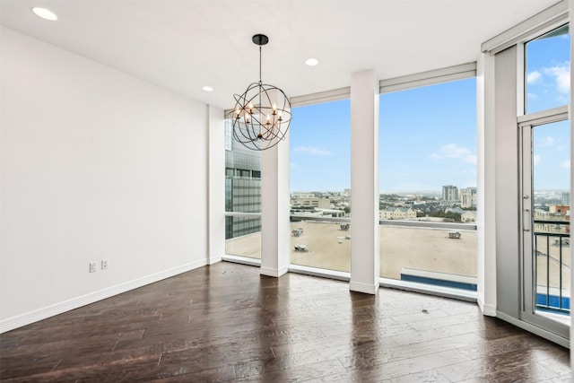 unfurnished dining area with expansive windows, a healthy amount of sunlight, dark wood-type flooring, and a notable chandelier