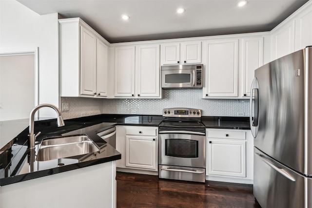 kitchen featuring dark wood-type flooring, sink, stainless steel appliances, decorative backsplash, and white cabinets