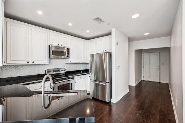 kitchen with sink, appliances with stainless steel finishes, dark hardwood / wood-style flooring, decorative backsplash, and white cabinets