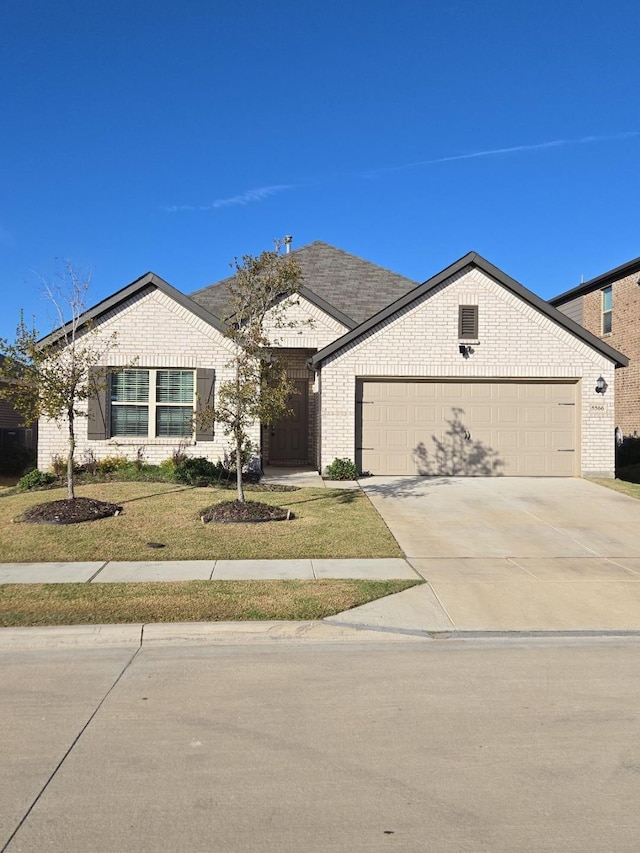 ranch-style home featuring a garage and a front lawn