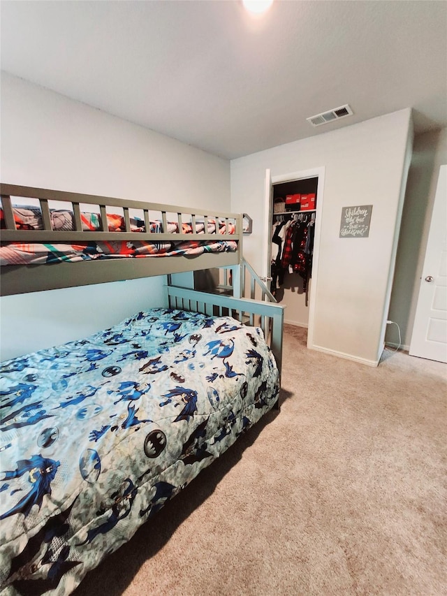 bedroom featuring a closet, a spacious closet, and carpet