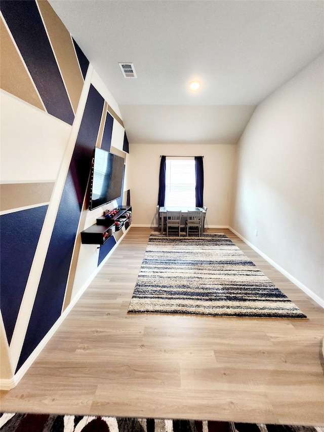 unfurnished living room with hardwood / wood-style flooring and vaulted ceiling