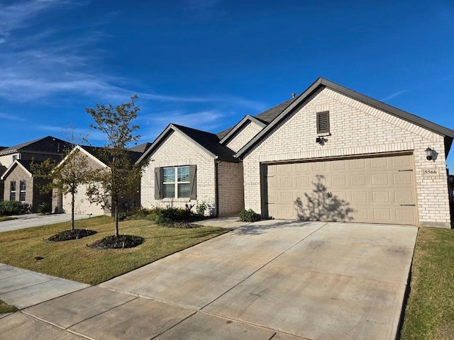 ranch-style house with a garage and a front lawn