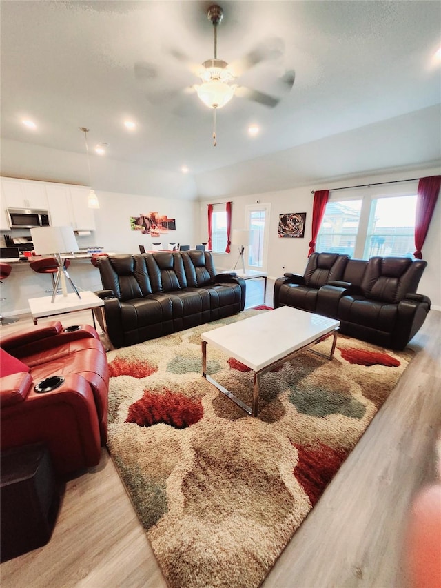 living room with plenty of natural light, light hardwood / wood-style floors, and ceiling fan