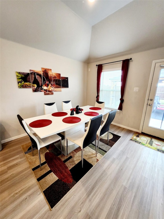 dining area featuring hardwood / wood-style flooring and vaulted ceiling