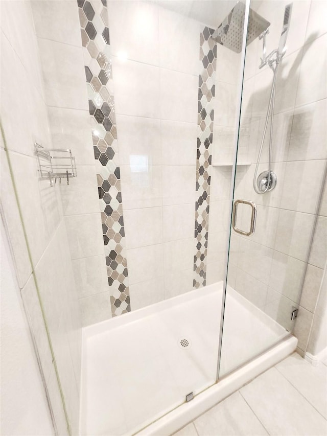 bathroom featuring a shower with shower door and tile patterned floors