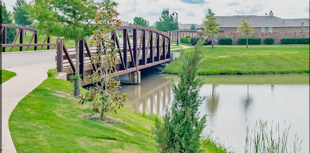 surrounding community with a yard and a water view