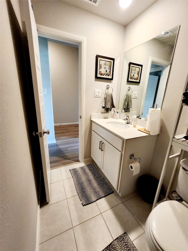 bathroom featuring tile patterned flooring, vanity, and toilet