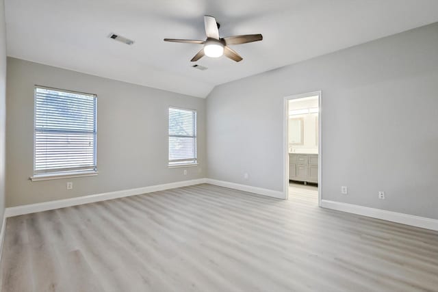 empty room with vaulted ceiling, ceiling fan, and light wood-type flooring