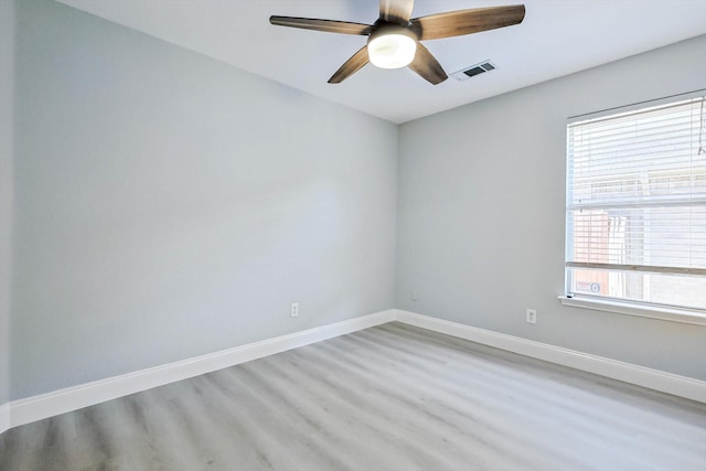 spare room with a healthy amount of sunlight, ceiling fan, and light wood-type flooring