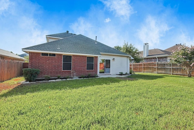 rear view of property featuring a yard