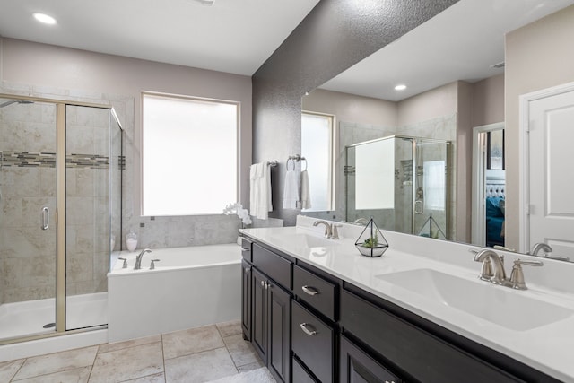 bathroom with vanity and shower with separate bathtub