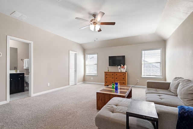 carpeted living room featuring ceiling fan, vaulted ceiling, and a wealth of natural light