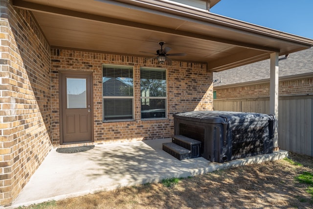 view of patio with ceiling fan and a hot tub