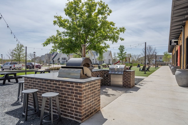 view of patio / terrace with an outdoor kitchen, an outdoor bar, and grilling area