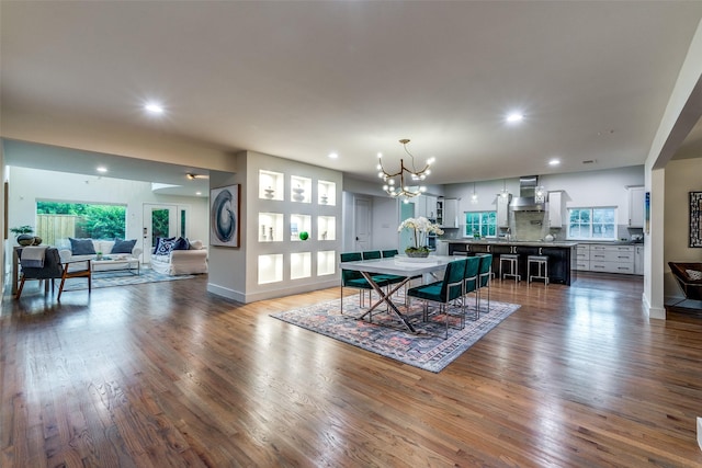 dining space with dark hardwood / wood-style flooring and an inviting chandelier