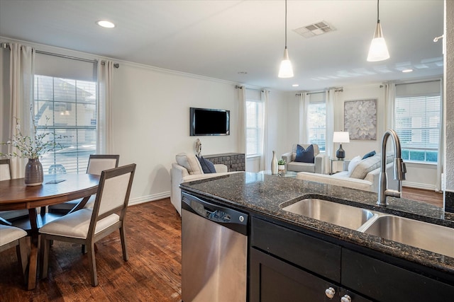 kitchen with sink, decorative light fixtures, dark stone countertops, stainless steel dishwasher, and dark hardwood / wood-style flooring