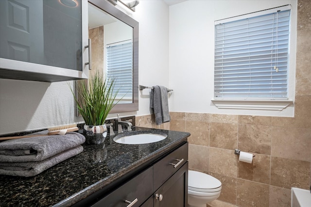 bathroom featuring tile walls, vanity, and toilet