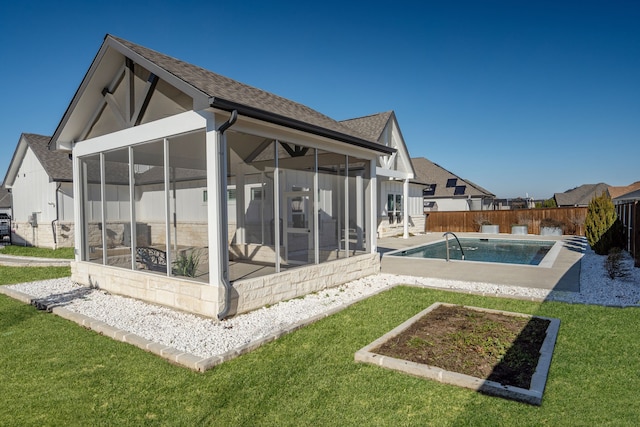 rear view of house with a fenced backyard, a yard, a fenced in pool, and a sunroom