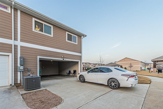 view of property exterior with central AC unit and a garage